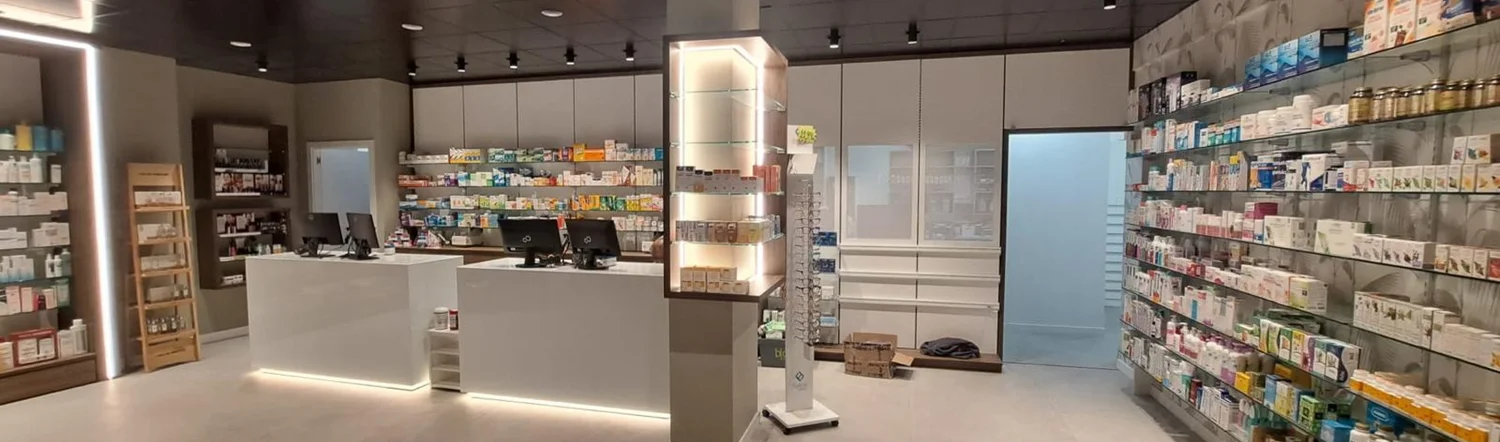 Mostradores y mobiliario de fondo. Puestos de atención blancos con exposición de fondo en un acabado oscuro.